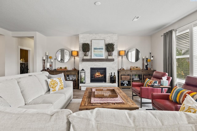 living room featuring washer / dryer, a textured ceiling, and a fireplace