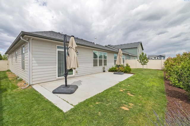 rear view of house featuring a patio area and a lawn