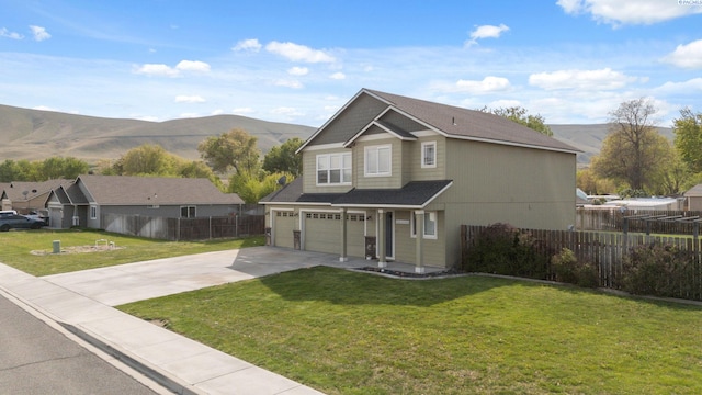 traditional-style home with a front lawn, a mountain view, concrete driveway, an attached garage, and fence