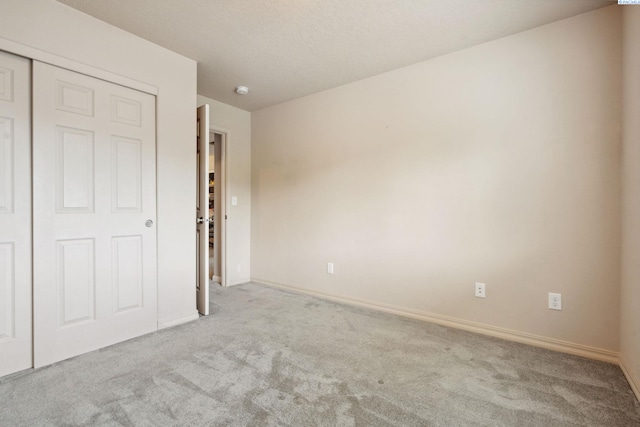 unfurnished bedroom with a closet, carpet floors, and baseboards