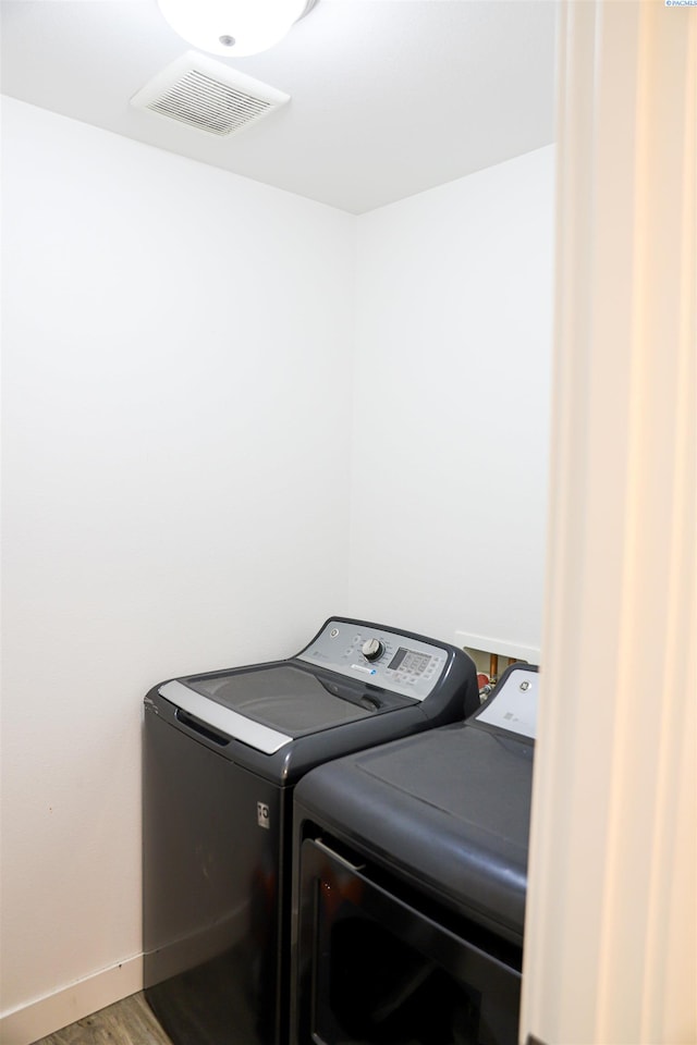 laundry room with washer and dryer and hardwood / wood-style floors