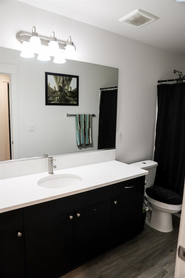 bathroom with vanity, hardwood / wood-style floors, curtained shower, and toilet