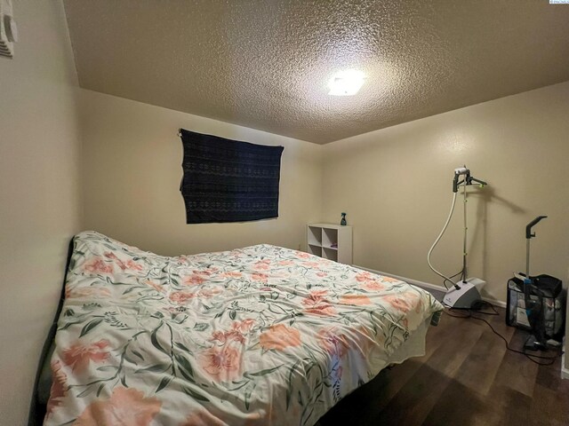 bedroom with wood-type flooring and a textured ceiling