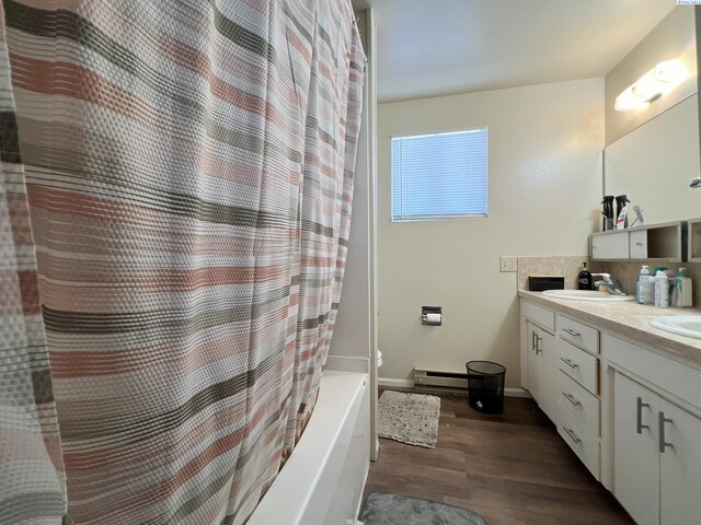 bathroom featuring vanity, shower / tub combo, hardwood / wood-style flooring, and a baseboard radiator