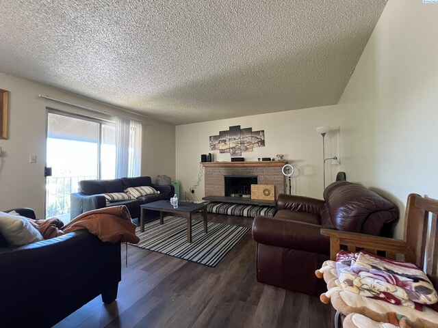 living room with dark hardwood / wood-style flooring, a fireplace, and a textured ceiling