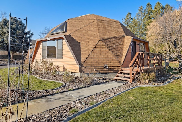 view of side of home featuring a wooden deck and a lawn