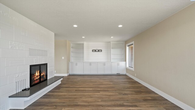 2003 W Canal Dr, Kennewick, WA 99336 - unfurnished living room featuring dark wood finished floors, a large fireplace, recessed lighting, and a textured ceiling