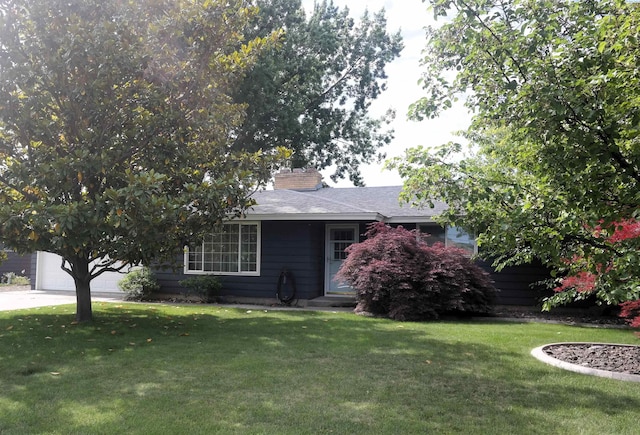 1815 W 16th Ave, Kennewick, WA 99337 - view of property hidden behind natural elements featuring a front lawn, a chimney, concrete driveway, a garage, and a shingled roof