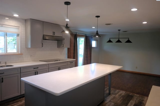1815 W 16th Ave, Kennewick, WA 99337 - kitchen with black electric cooktop, under cabinet range hood, dark wood finished floors, a kitchen island, and recessed lighting