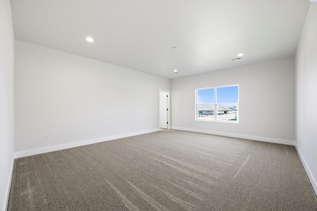 carpeted spare room featuring visible vents, baseboards, and recessed lighting