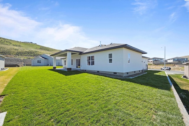 back of house with a lawn and crawl space