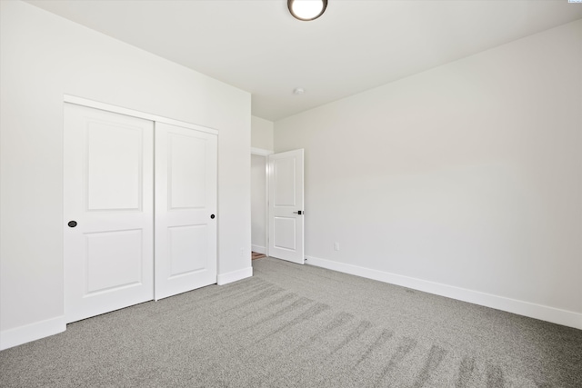 unfurnished bedroom featuring baseboards, a closet, and carpet