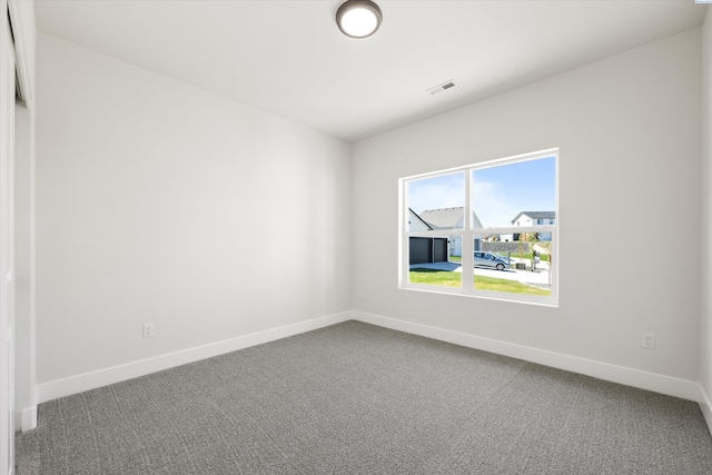 empty room with visible vents, baseboards, and carpet floors