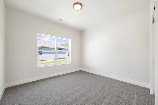 empty room featuring visible vents, baseboards, and carpet