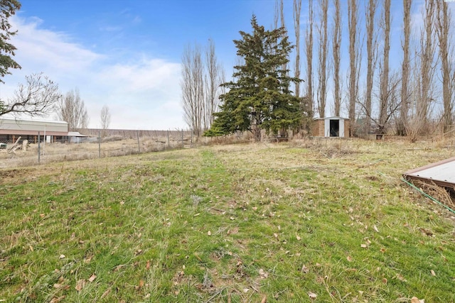 view of yard featuring a rural view and an outdoor structure