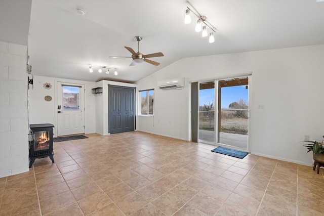 interior space featuring a wall mounted air conditioner, light tile patterned floors, vaulted ceiling, and ceiling fan