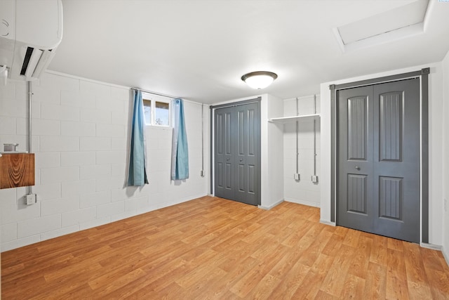 unfurnished bedroom featuring multiple closets and light hardwood / wood-style floors