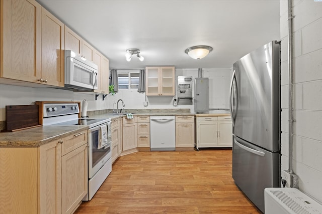 kitchen with light brown cabinetry, sink, light hardwood / wood-style flooring, and stainless steel appliances