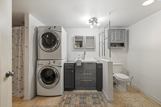 laundry area featuring tile patterned flooring, stacked washer / drying machine, and sink