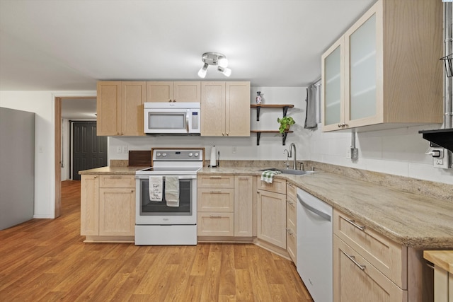 kitchen featuring sink, white appliances, light wood-type flooring, and light brown cabinets