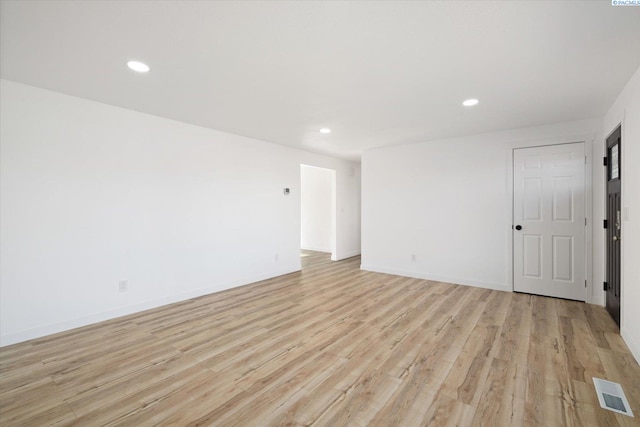 empty room with baseboards, light wood-style flooring, visible vents, and recessed lighting