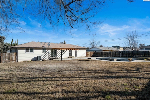 back of house with entry steps, a lawn, a patio area, and fence