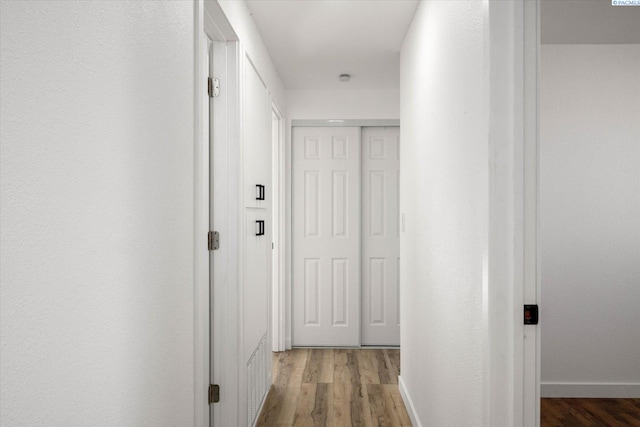 hall with baseboards and wood finished floors