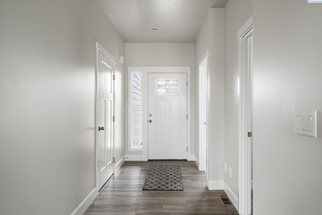 foyer entrance with dark hardwood / wood-style floors and a textured ceiling