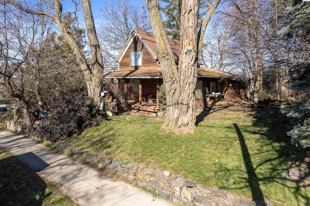 view of side of home featuring covered porch and a lawn