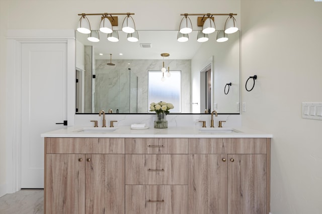 bathroom with double vanity, marble finish floor, a marble finish shower, and a sink