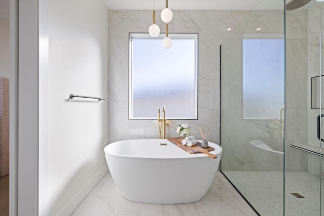 bathroom featuring marble finish floor, baseboards, a freestanding tub, and a marble finish shower