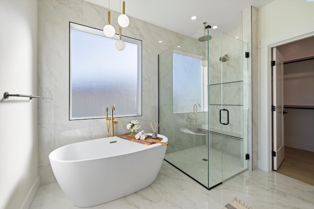 full bathroom with a stall shower, marble finish floor, and a soaking tub