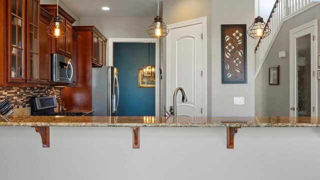 2876 Crosswater Loop, Richland, WA 99354 - kitchen with appliances with stainless steel finishes, glass insert cabinets, a sink, light stone countertops, and recessed lighting