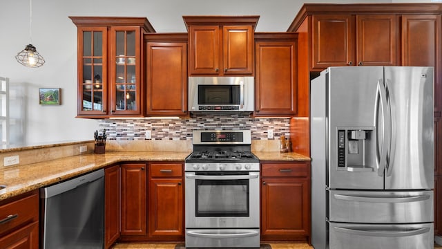2876 Crosswater Loop, Richland, WA 99354 - kitchen featuring stainless steel appliances, light stone counters, backsplash, and glass insert cabinets