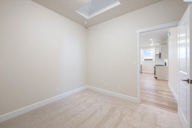 empty room with a skylight and light carpet