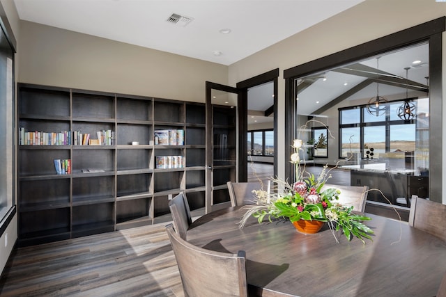 dining space featuring wood-type flooring and vaulted ceiling