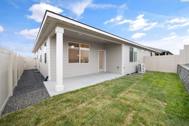 rear view of property with a yard, a patio, and ac unit