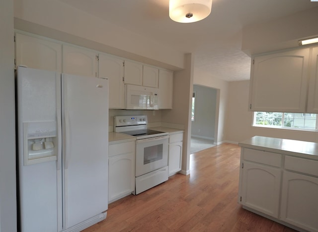 610 Dilke St, Pullman, WA 99163 - kitchen with white appliances, white cabinets, light wood finished floors, and light countertops