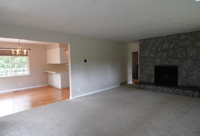 610 Dilke St, Pullman, WA 99163 - unfurnished living room featuring light colored carpet, a chandelier, and a stone fireplace