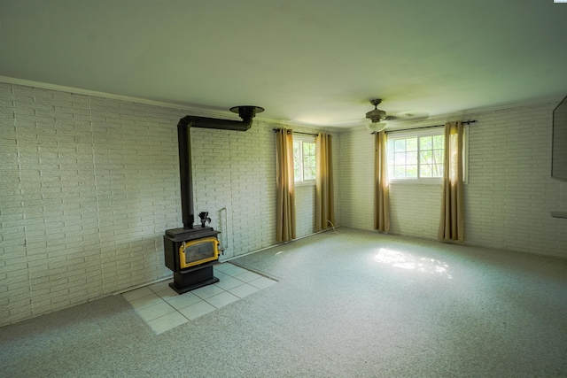 610 Dilke St, Pullman, WA 99163 - unfurnished living room with brick wall, a wood stove, ceiling fan, and carpet flooring