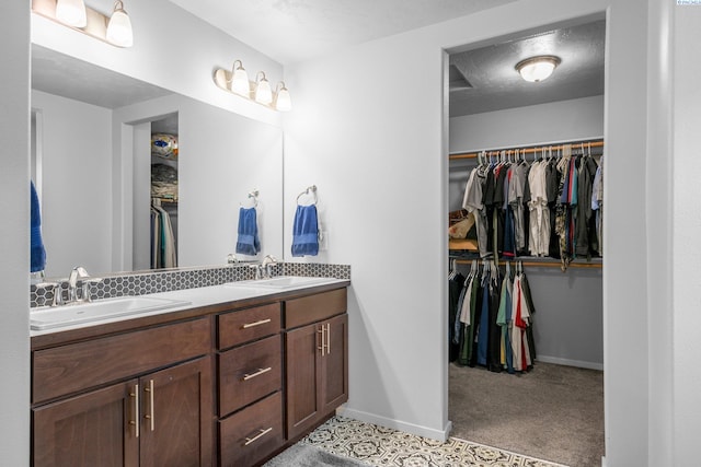 6217 Sidon Ln, Pasco, WA 99301 - full bathroom with double vanity, baseboards, and a walk in closet