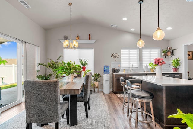 6217 Sidon Ln, Pasco, WA 99301 - dining space with a chandelier, light wood-type flooring, vaulted ceiling, and recessed lighting