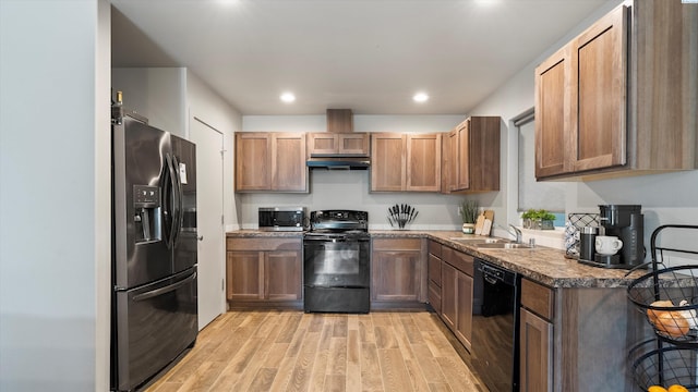 520 Whitefish Ln, Pasco, WA 99301 - kitchen with black appliances, under cabinet range hood, light wood-style floors, recessed lighting, and dark countertops