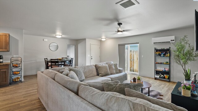 520 Whitefish Ln, Pasco, WA 99301 - living area with a wall mounted AC, light wood-style floors, and ceiling fan