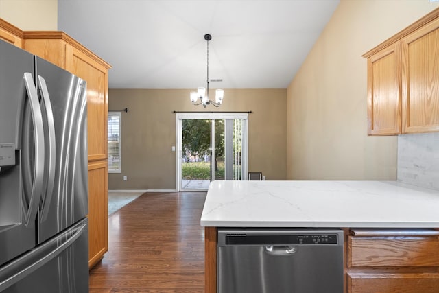 kitchen with light stone counters, decorative light fixtures, a chandelier, appliances with stainless steel finishes, and dark hardwood / wood-style flooring