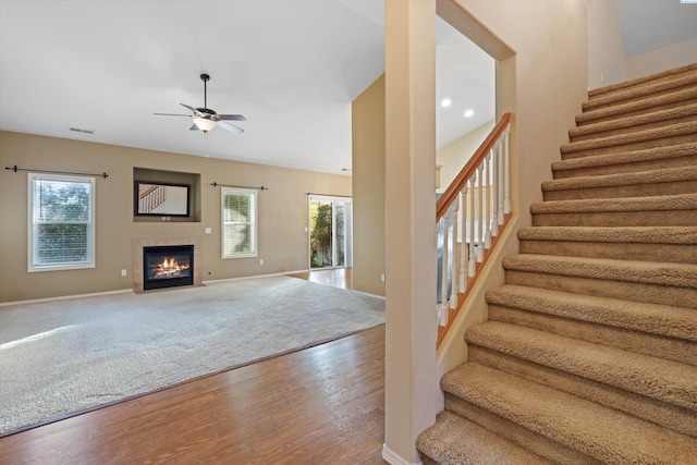 interior space with hardwood / wood-style flooring, ceiling fan, and a towering ceiling