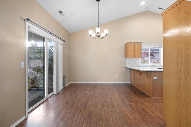 unfurnished dining area featuring lofted ceiling, an inviting chandelier, and dark hardwood / wood-style flooring