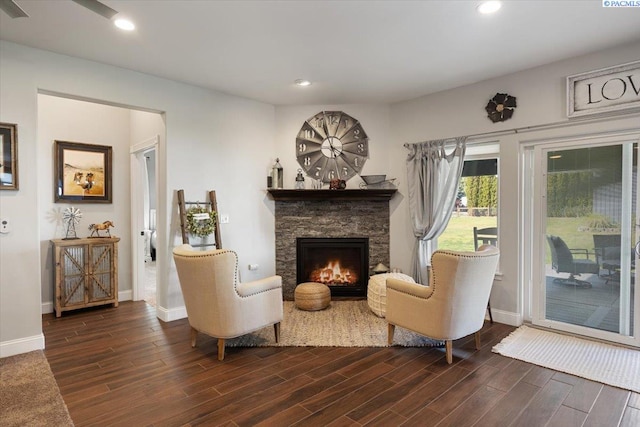 sitting room featuring dark wood-type flooring, baseboards, a fireplace, and recessed lighting