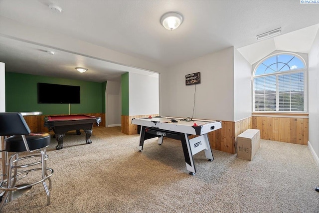 playroom with billiards table, carpet flooring, wooden walls, wainscoting, and vaulted ceiling