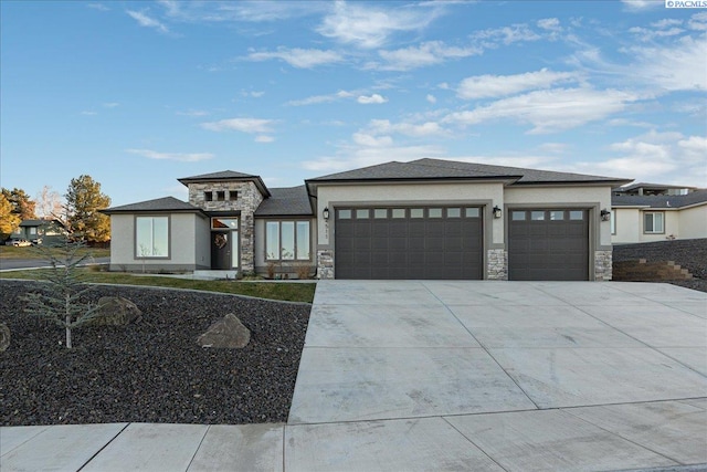 prairie-style home featuring an attached garage, stone siding, concrete driveway, and stucco siding